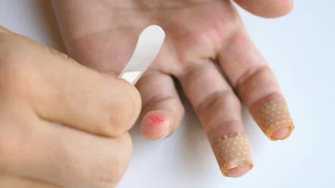 Man applying band aid patch on cuts wound on fingers. Male putting medical Fotos de archivo