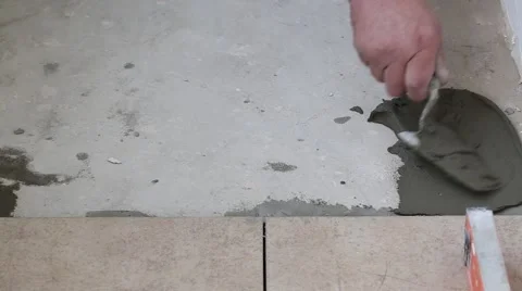 Man applying ceramic tile to a floor, close up Stock Footage 64542944