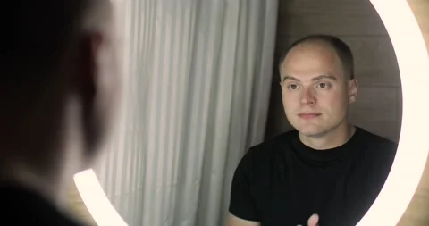 Man is applying cleansing foam on face to washing it and looking at mirror. Stock Footage 137438483