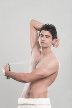 Man applying deodorant over his body Stock Photos