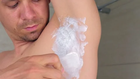 Man applying depilation cream on armpit using spatula in bathroom at home. Stock Footage 116369306