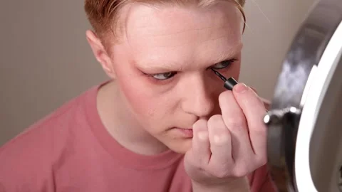 Man Applying Eyeliner in Front of Mirror Stock Footage 310032336