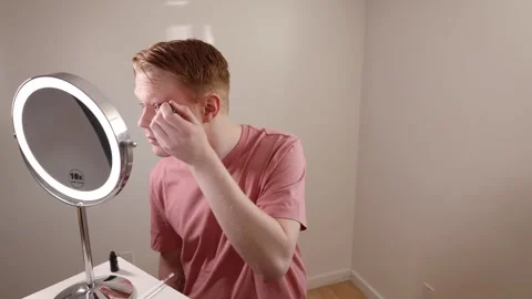 Man Applying Eyeliner in Front of Mirror Stock Footage 310033067