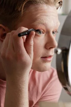 Man Applying Eyeliner in Front of Mirror Stock Photos