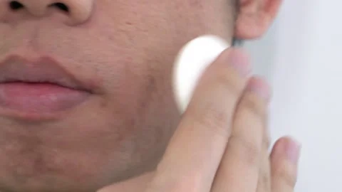 A man is applying makeup to his face Stock Footage 314612138