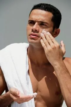 Man applying moisturizer to face Stock Photos