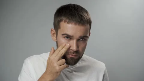 Man is applying moisturizing cream on his face Stock Footage 233517051