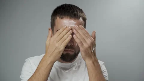 Man is applying moisturizing cream on his face Stock Footage 233517490