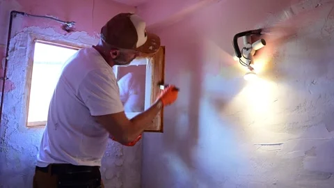Man applying plaster on a wall during home renovation Видео 346167972