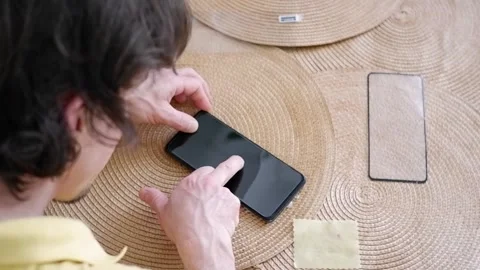 Man applying protective glass on smartphone screen Stock Footage 338008534