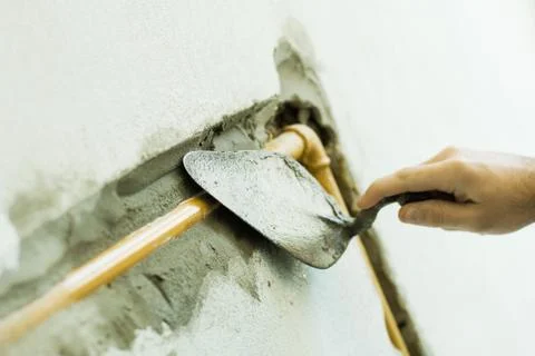 Man applying putty to pipe, cropped view of hand Stock Photos