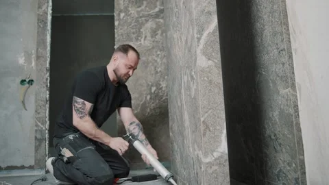 Man applying sealant to tile in slow motion during renovation project Stock-Footage 307042029