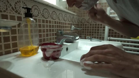 Man Applying Shaving Cream in Bathroom: A Daily Grooming Routine Stock Footage 332068363