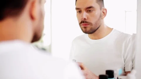 Man applying shaving foam to beard at bathroom Stock Footage