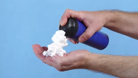 Man applying shaving foam to hand. Blue background Stock Footage 158874169