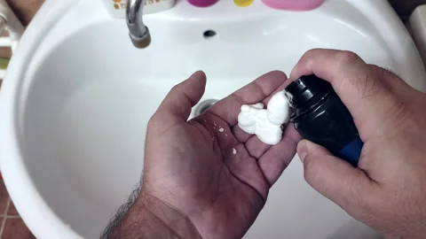 A man applying shaving foam on his hand, first-person view Stock Footage 162571915