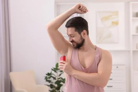 Man applying solid deodorant at home. Space for text 스톡 사진