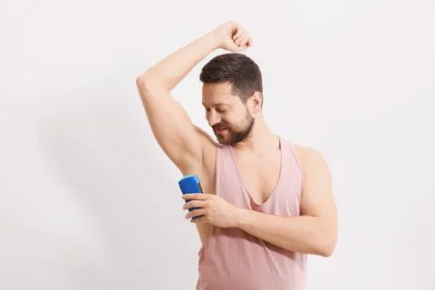 Man applying solid deodorant on white background Stock Photos