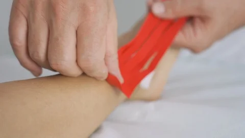 Man Applying Special Physio Tape On Woman's ankle Stock Footage 113404748