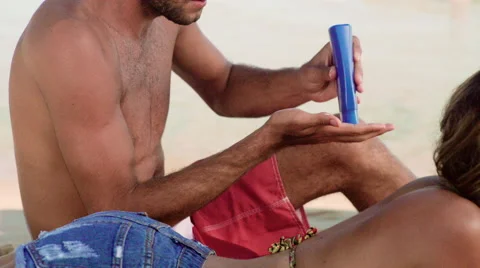 Man applying sunscreen lotion on woman's back at Ipanema beach Stock Footage 59376738