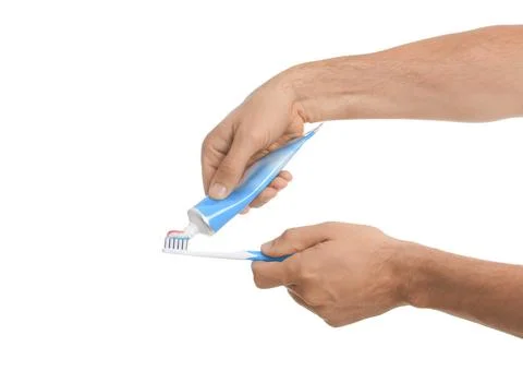Man applying toothpaste on brush against white background, closeup 스톡 사진
