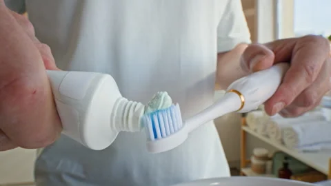Man Applying Toothpaste on Toothbrush over Sink before Brushing Teeth Stock Footage 313508675