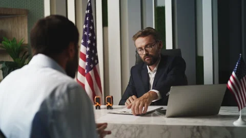 Man applying for U.S. visa at embassy receiving application refusal from officer Stock Footage 327784945