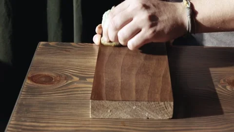 Man applying wood stain. applying oil on a wooden board. application of wood  Stock Footage 166330738