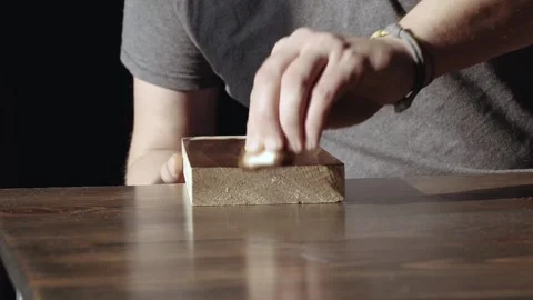 Man applying wood stain. applying oil on a wooden board with a sponge. applic Stock Footage 166330740