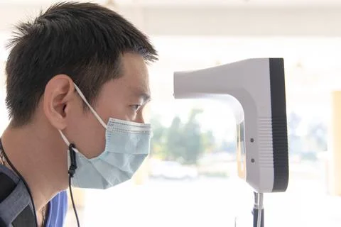 Man approached the forehead thermometer sensor to detect body heat,Temperatur Stock Photos