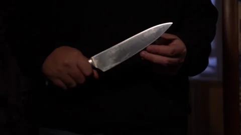 A Man Approaches in the Dark, Holding a Large Knife in His Hands. Stock Footage 147338850