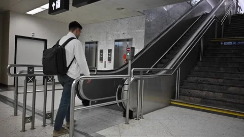 A man approaches the escalator at the airport Stock Footage 252126347