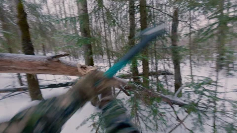 A man approaches a fallen tree and cuts its end with an axe. Stock Footage 322759527