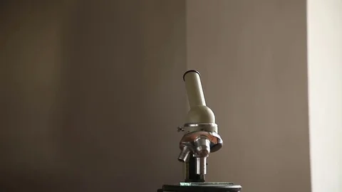 The man approaches the microscope and looks into it Stock Footage 75559191