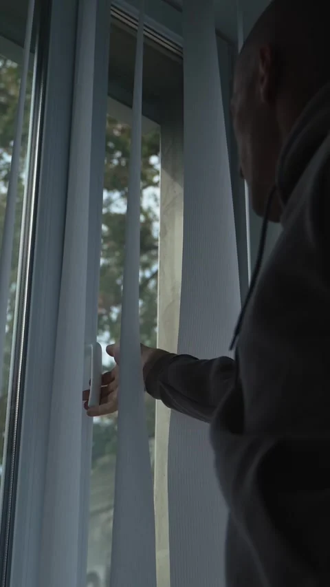 Man approaches the open window and closes it. Silhouette of a man Stock Footage 346018945