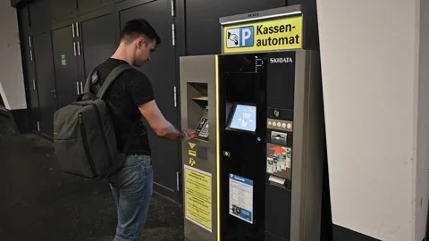 A man approaches the parking meter to pay for parking Stock Footage 252098747