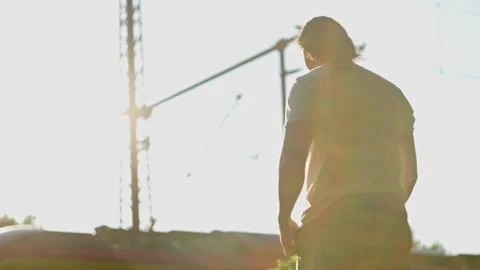 A man approaches the railroad tracks. On the platform on a sunny day and waits Stock Footage 314618975