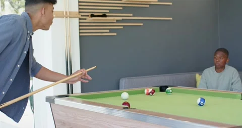 Man approaching pool table and striking ball with cue stick then shaking Stock Footage 339272117
