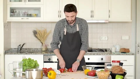 Man in an apron cooking in the kitchen at home Stock Footage 131454884