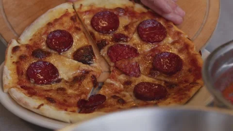 A man in an apron pulls pizza out of a wood-fired oven. A cook pulls out a Stock Footage 259062927