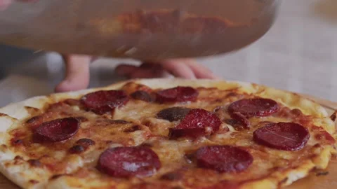 A man in an apron pulls pizza out of a wood-fired oven. A cook pulls out a Stock Footage 259063018