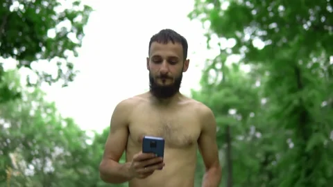 A man of Arab appearance with a beard and without a T -shirt runs in a park with Stock Footage 199291701