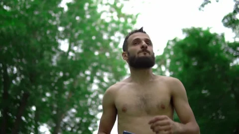 A man of Arab appearance with a beard and without a T -shirt runs in a park with Stock Footage 199291779