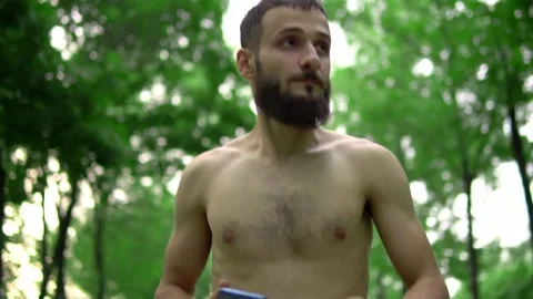 A man of Arab appearance with a beard and without a T -shirt runs in a park with Stock Footage 199291853