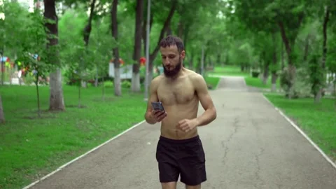 A man of Arab appearance with a beard and without a T -shirt runs in a park with Stock Footage 199291920