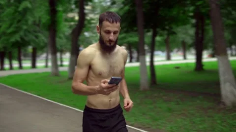 A man of Arab appearance with a beard and without a T -shirt runs in a park with Stock Footage 199292208