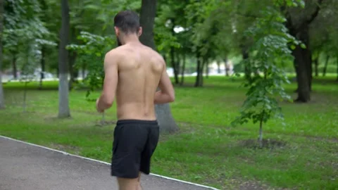 A man of Arab appearance with a beard and without a T -shirt runs in a park with Stock Footage 199292716