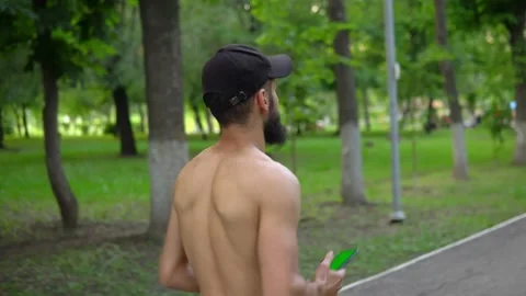 A man of Arab appearance with a beard and without a T -shirt runs in a park with Stock Footage 199292962