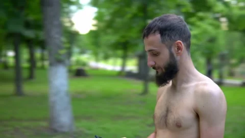 A man of Arab appearance with a beard and without a T -shirt runs in a park with Stock Footage 199293177
