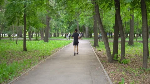 A man of Arab appearance with a beard runs in a park with a smartphone Stock Footage 199397525